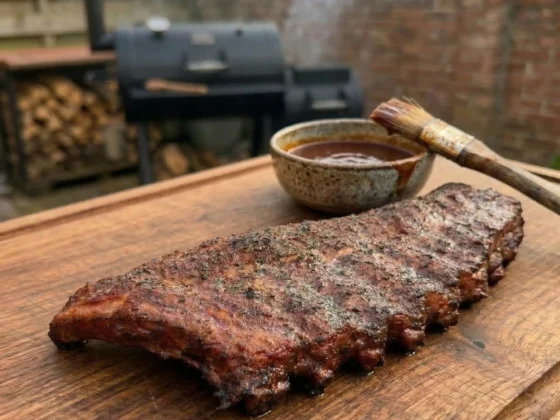 Sparerib met ketting op een rustieke snijplank van de bbq low & slow gegaard