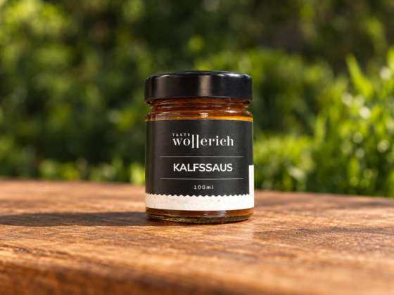 Glazen pot Kalfssaus Wollerich met zwart etiket en deksel op een houten tafel in het groen