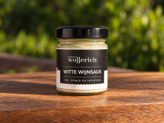 Pot Witte wijnsaus Wollerich met zwart deksel op een houten tafel in een groene buitenomgeving